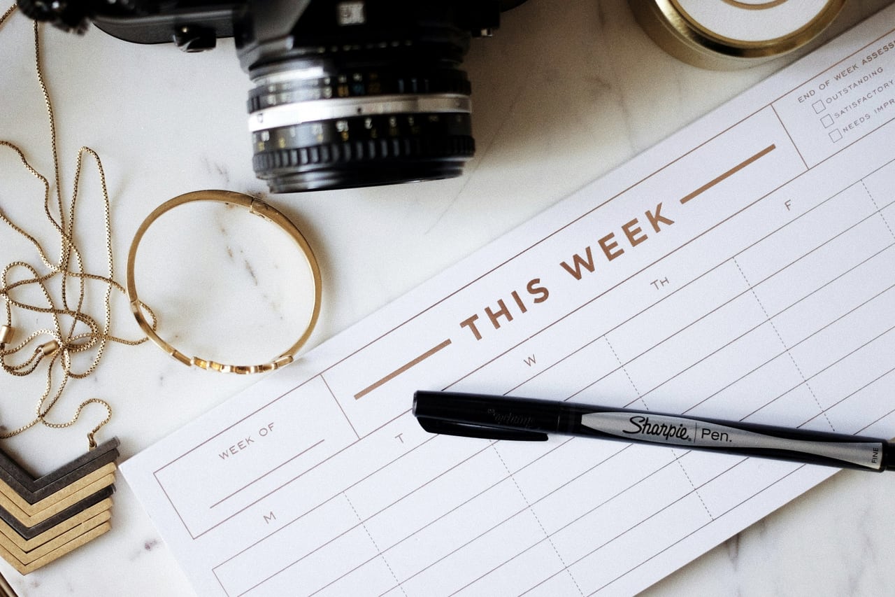 Agenda familial ouvert sur la table, semaine notée à la main.