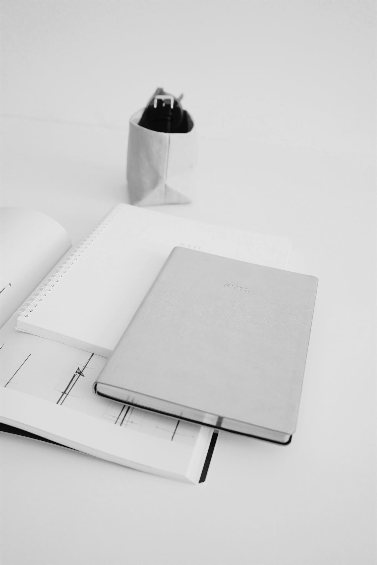 Carnet en cuir posé sur un bureau en bois, ambiance de travail soignée.