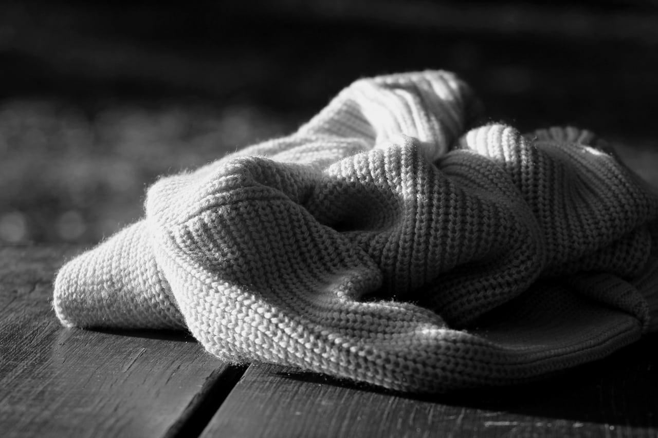 Plaid en cachemire plié sur un canapé, douceur d'intérieur soigné.
