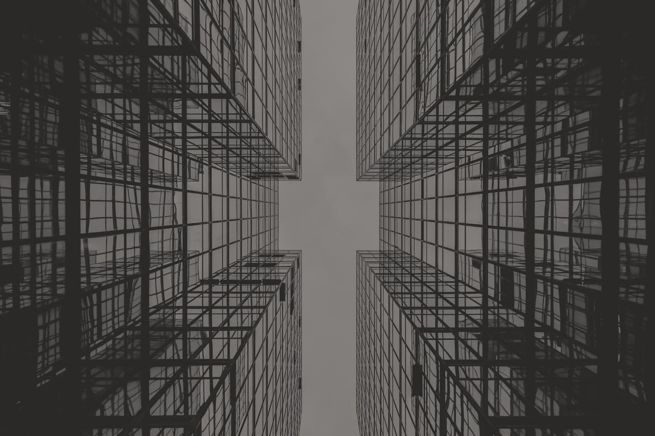 Façade vitrée d'un immeuble, reflet abstrait et lignes verticales.